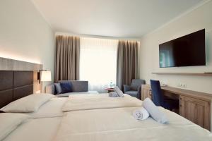 塞巴特阿尔贝克Hotel Residenz WALDOASE的酒店客房设有两张床和一台平面电视。