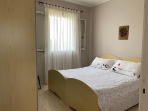 托雷莫泽Villetta Sabbia d'Oro的一间卧室配有带白色床单和枕头的床。