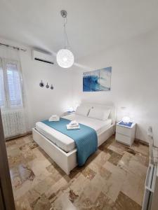 切萨雷奥港Albatros B&B Porto Cesareo的白色卧室配有床和蓝色毯子