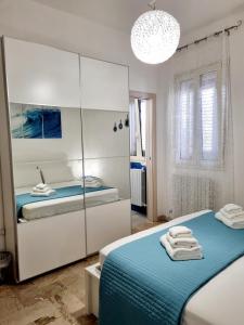 切萨雷奥港Albatros B&B Porto Cesareo的一间白色卧室,配有两张床和镜子