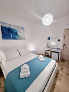 切萨雷奥港Albatros B&B Porto Cesareo的一间卧室配有一张大白色床和蓝色毯子