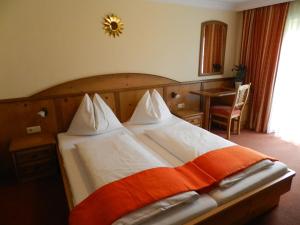 海德福安沃勒塞Landhotel Gersbach-Gut的一间卧室配有一张带橙色和白色毯子的床