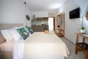 帕尔加OLEA Luxury Apartments的一间带白色大床的卧室和一间厨房
