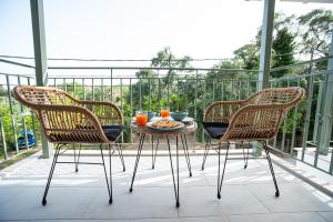 帕尔加OLEA Luxury Apartments的阳台上配有两把椅子和一张桌子及一盘食物