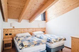 博萨迪法萨多洛米亚住宅公寓式酒店的配有木天花板的客房设有两张床。