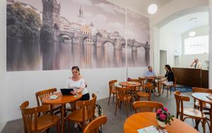 布拉格城市中心酒店的坐在餐厅桌子上的女人