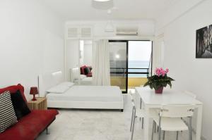 拉纳卡Stadem Studios的白色的客厅配有白色的床和一张桌子