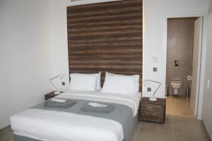 帕福斯Gold Lagoon Kosher Hotel的一间卧室配有一张大床和木制床头板