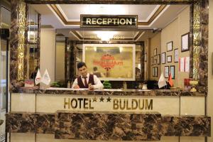 安卡拉Buldum Otel的一个人站在旅馆柜台后面