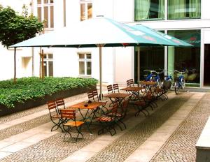 柏林柏林市中心金色旅馆的一组桌子和椅子,放在伞下