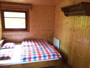 斯科林特普利采斯科林特普利采度假屋的木制客房的一张床位,设有窗户