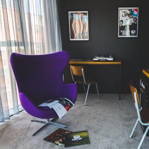 利物浦The Baltic Hotel的一张桌子的房间里一张紫色椅子
