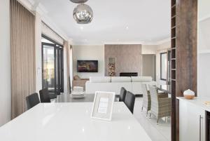 香槟谷Eleven on Tumbleweed, Cathkin Estates的用餐室以及带白色桌椅的起居室。