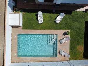 奇克拉纳－德拉弗龙特拉Chalet Santi Playa de la Barrosa的享有带2把草坪椅的游泳池的顶部景致