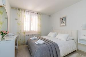 波雷奇Apartments Lavizatic的白色的卧室设有床和窗户
