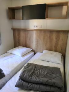 比斯卡罗斯Mobil Home camping 5 étoiles Biscarrosse的带两张床的小房间,带水ermottermott