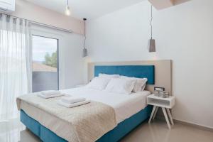 卡拉马孔Corner45 Apartments的卧室配有蓝色和白色的床和窗户。
