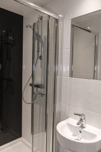卡迪夫For Students Only - Premium Accommodation at Eclipse Student Accommodation in Cardiff的带淋浴、盥洗盆和镜子的浴室