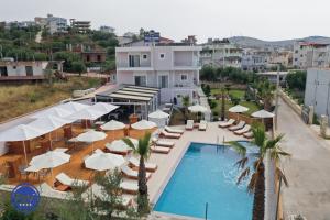卡萨米尔Blue Water Hotel Ksamil的一个带躺椅和遮阳伞的游泳池