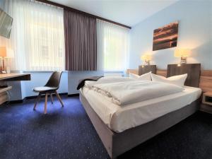 柏林梅拉罗斯·芬·舒酒店的一间卧室配有一张床、一张桌子和一把椅子