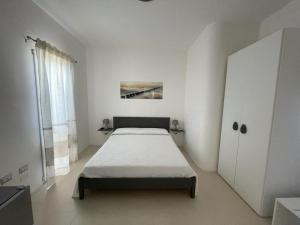斯廷蒂诺Gassa d amante Affittacamere的一间白色卧室,配有床和橱柜