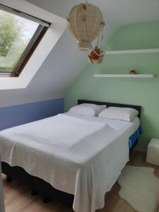 瓦夫尔Les prussiens的一间卧室配有一张带白色床单的床和一扇窗户。