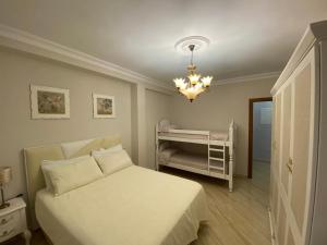 多列毛利诺斯Perla Del Sol 1 l的卧室配有白色的床和吊灯。