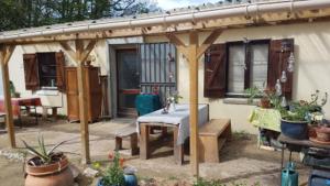 Sougères-en-PuisayeLovely 2-Bed shepherds hut in a Forest的一个带桌子的庭院和一座种植了盆栽植物的房子