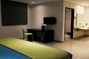 贾拉普Mision Express Xalapa Centro的一间卧室配有一张床、一张书桌和一台电视
