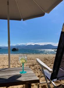 阿布拉奥O Sitio - Ilha Grande的坐在海滩上的桌子上喝一杯葡萄酒