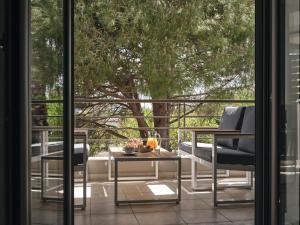扎金索斯镇La Palma Apartment的阳台配有桌椅和一棵树。