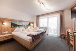 莱尔莫斯Apart Haus Alpenhof的一间卧室设有一张大床和大窗户
