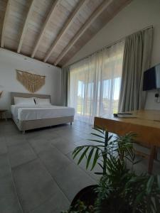 斯卡拉埃雷索Lithos Villas的一间卧室设有一张床和一个大窗户