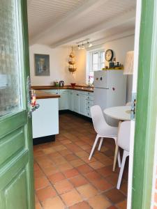 马斯塔尔Færgestræde 45的厨房配有桌子和白色冰箱。