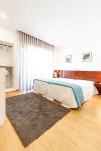 波瓦-迪瓦尔津Apartamento Mar & Sol的卧室配有一张床,地板上铺有地毯
