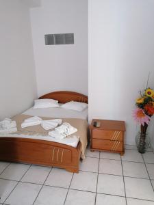 埃尔莫波利斯ANTONIS ROOMS 2的一间卧室配有床、床头柜和鲜花