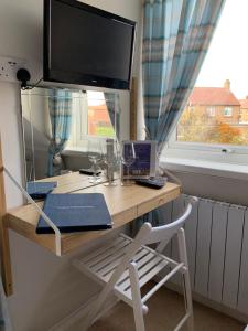 锡豪西斯Holly Trees的一张桌子,在窗户前配有一台电视和一把椅子