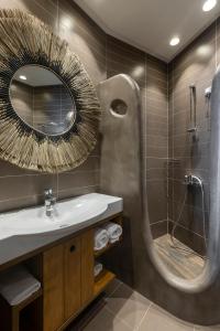 卡利斯托斯Anastasia Hotel & Suites Mediterranean Comfort的浴室配有盥洗盆和带镜子的淋浴