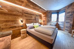 瓦尔富尔瓦Chrys b&b的一间带木墙的卧室和一张位于客房内的床