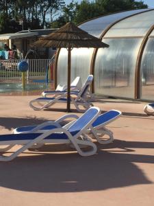 乌伊斯特勒昂ALINOA的游乐场里的一排躺椅和一把遮阳伞