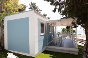 莱波拉诺Porto Pirrone Camping的蓝色和白色的外墙小房子
