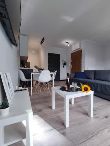 什切青River House - Apartament z ogródkiem的客厅配有白色桌子和蓝色沙发