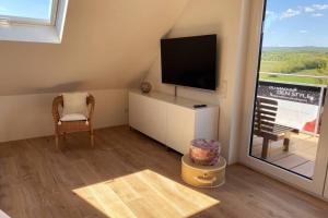 威斯巴登100 qm sonnendurchflutetes Loft, Sonnenbalkon的客房设有电视、椅子和窗户。