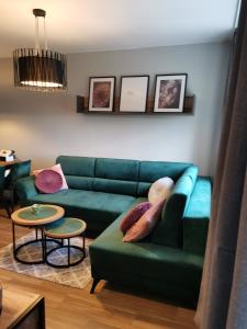 马尔堡Apartament z widokiem na Zamek的客厅配有绿色沙发和桌子