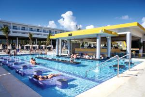 蓬塔卡纳Riu Republica - Adults Only - All Inclusive的水中人聚在酒店的游泳池