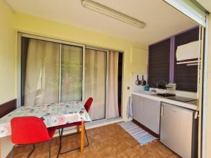 圣安娜多巴哥一室公寓的厨房配有桌子、红色椅子和窗户