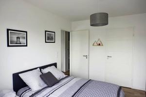 圣纳泽尔T2 moderne, lumineux, proche de la mer et des principaux accès routiers的卧室配有白色墙壁的床