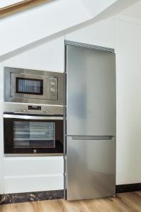 阿斯托加Apartamento El Ático的厨房里配有不锈钢冰箱和微波炉