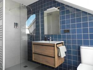 阿斯托加Apartamento El Ático的蓝色瓷砖浴室设有水槽和镜子