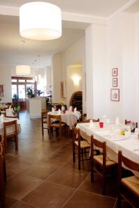 Poggio PicenzePaneolio Food and Drink B&B的用餐室配有白色的桌子和木椅
